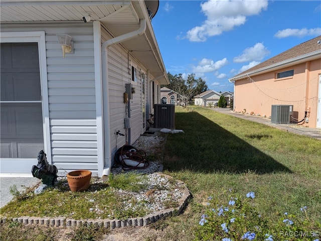 view of property exterior with a lawn and central AC