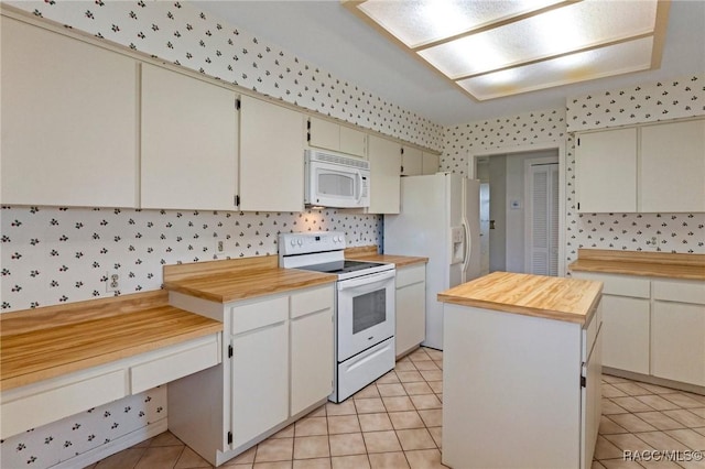 kitchen with a kitchen island, wooden counters, light tile patterned floors, and white appliances