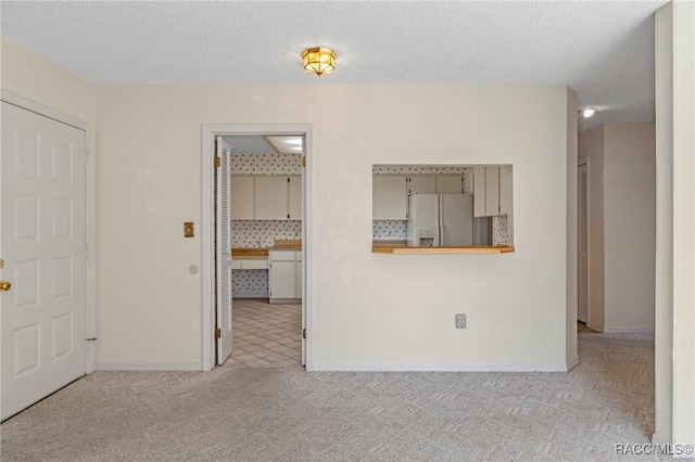 carpeted spare room with a textured ceiling