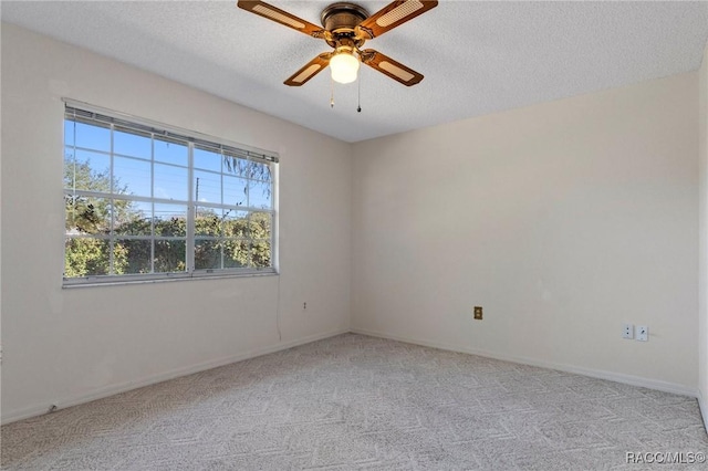 spare room with ceiling fan, light colored carpet, and a textured ceiling