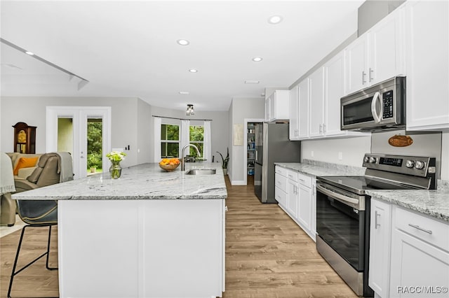 kitchen with sink, white cabinets, stainless steel appliances, and light hardwood / wood-style flooring