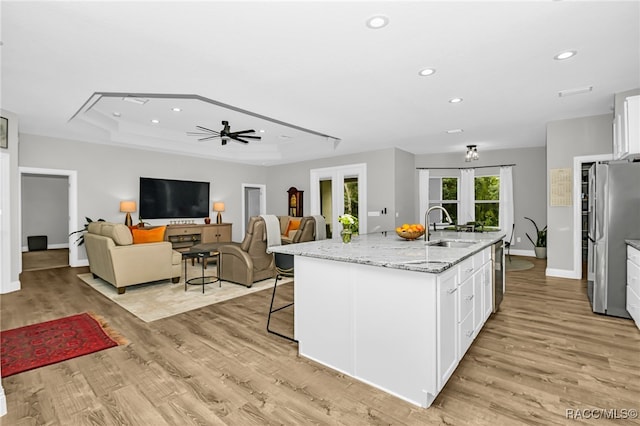 kitchen with white cabinetry, sink, and light hardwood / wood-style floors