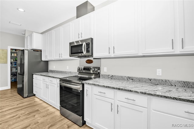 kitchen featuring white cabinets, appliances with stainless steel finishes, light hardwood / wood-style flooring, and light stone countertops