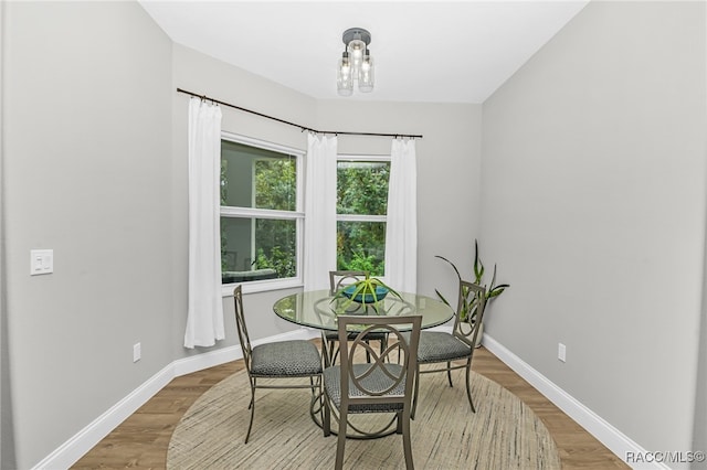 dining space with wood-type flooring and a chandelier