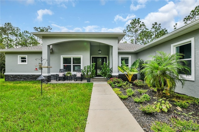 view of exterior entry with a lawn