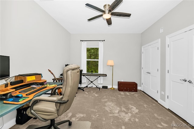 carpeted office space with ceiling fan