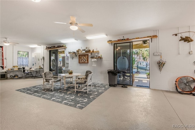 dining area featuring ceiling fan and concrete flooring