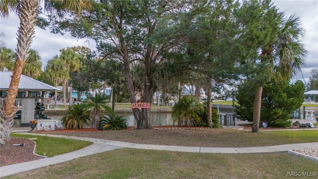 view of property's community featuring a lawn and a water view