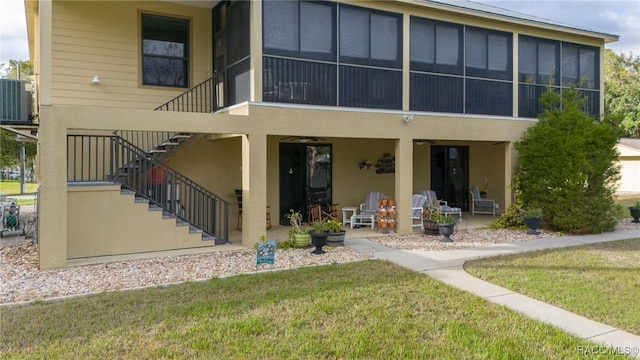 back of property featuring a patio area, a yard, and central AC