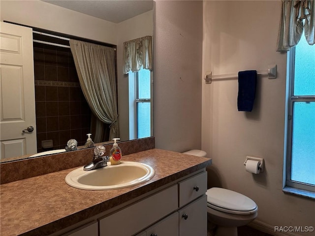 bathroom with curtained shower, toilet, and vanity