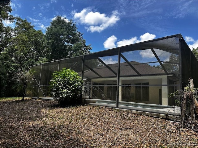 back of house featuring glass enclosure