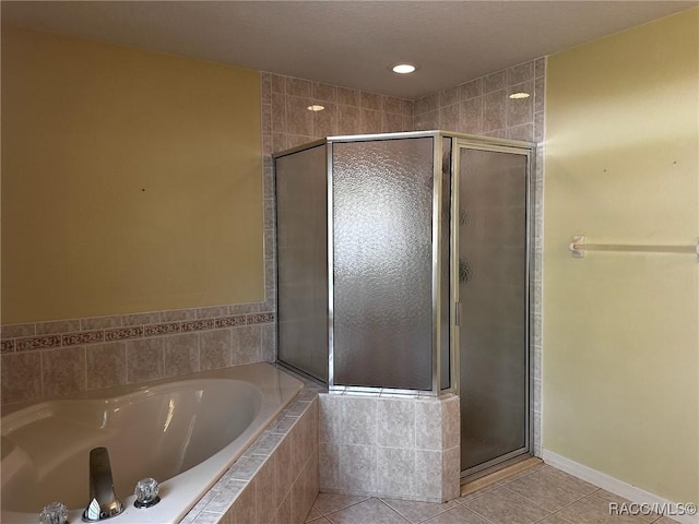 bathroom with tile patterned floors, a garden tub, and a shower stall