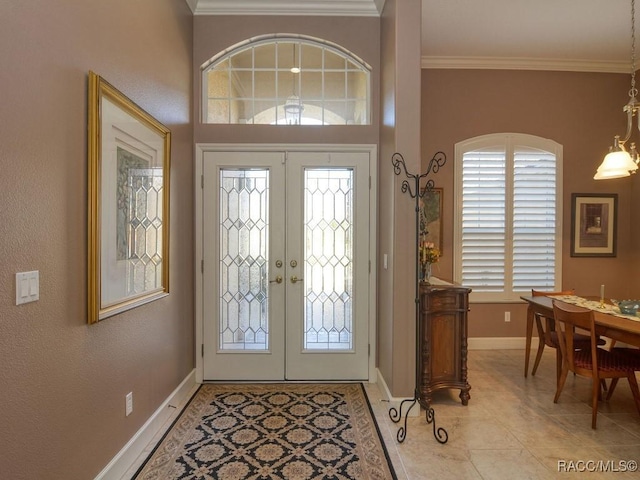 tiled entrance foyer with a wealth of natural light, ornamental molding, and french doors