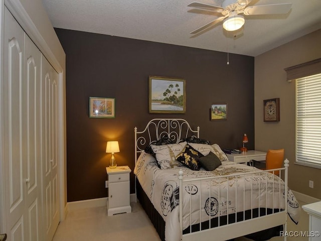 bedroom featuring ceiling fan, light colored carpet, and a closet