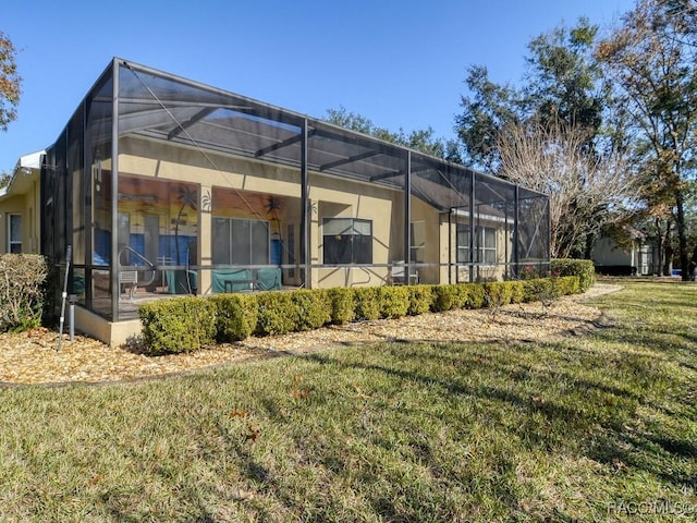 back of property featuring a lanai and a lawn