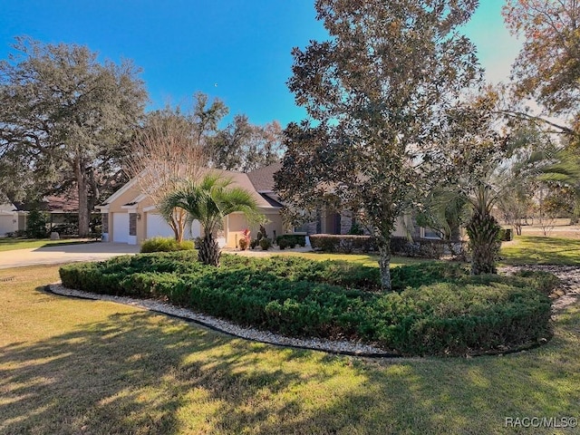 obstructed view of property featuring a garage and a front lawn