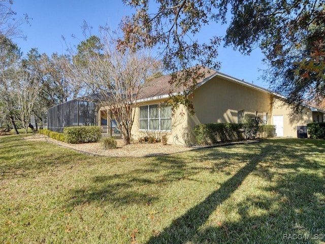 view of side of property featuring a lanai and a yard