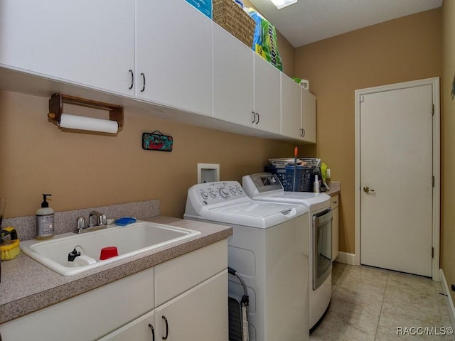 washroom featuring cabinets, washing machine and clothes dryer, and sink