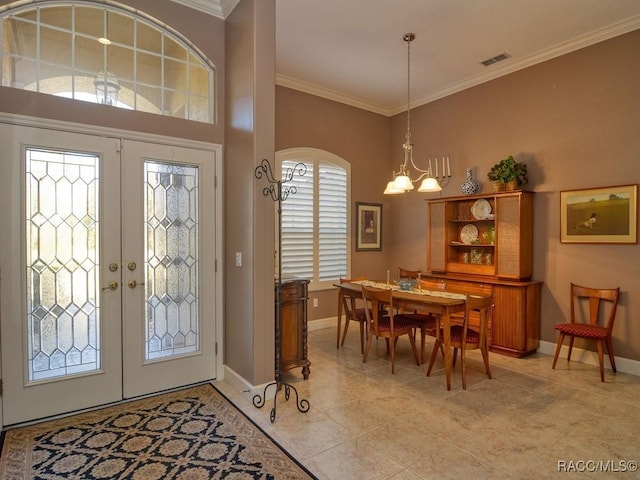 entryway featuring a chandelier, crown molding, and french doors