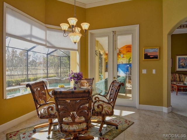 tiled dining room featuring ornamental molding, a healthy amount of sunlight, and a chandelier