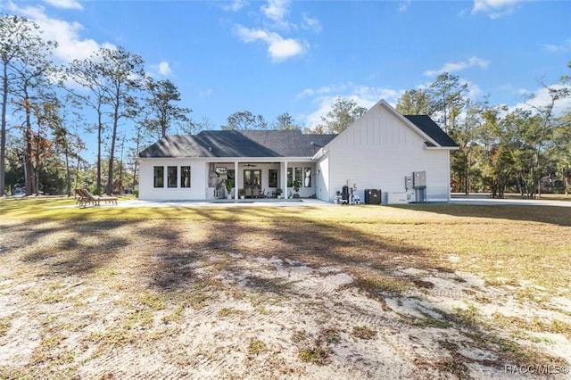 back of property featuring a lawn and central AC unit