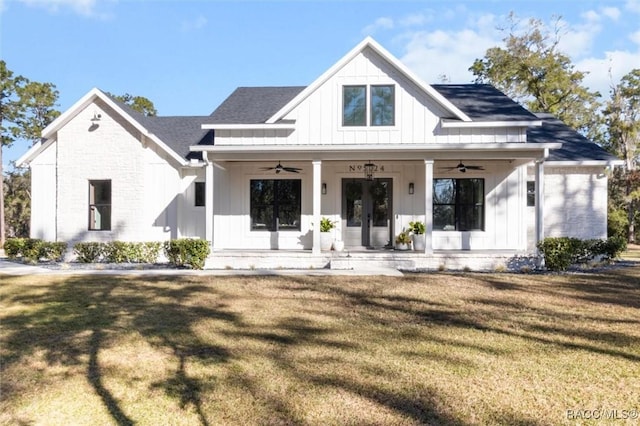 modern farmhouse style home with ceiling fan, a front lawn, and covered porch