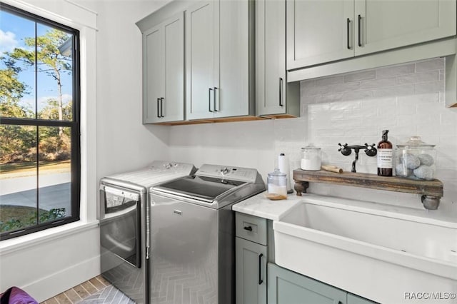 clothes washing area with cabinets, tile patterned floors, and independent washer and dryer