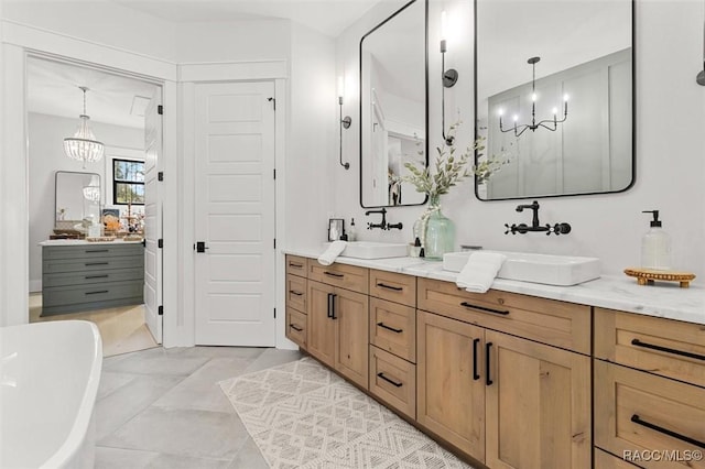 bathroom with a bathtub, vanity, and a notable chandelier