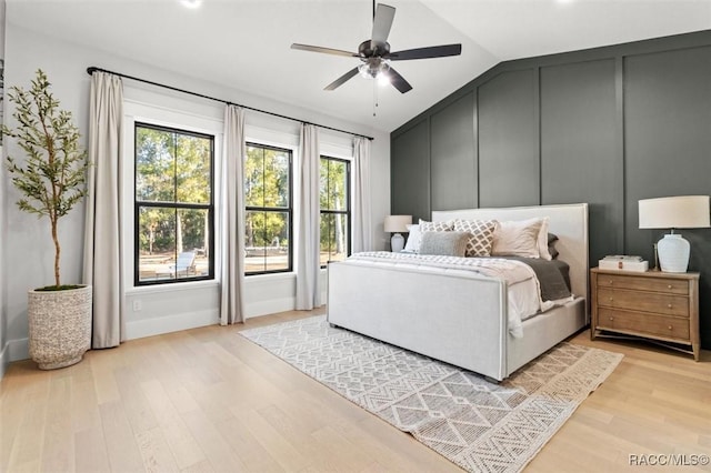 bedroom with ceiling fan, vaulted ceiling, and light hardwood / wood-style flooring