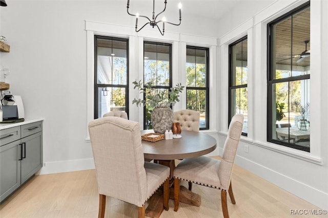 dining area with light wood-type flooring and a notable chandelier