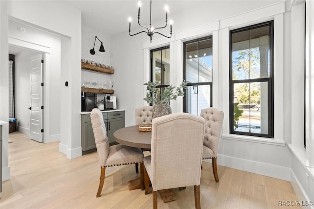 dining room with light hardwood / wood-style floors and a notable chandelier