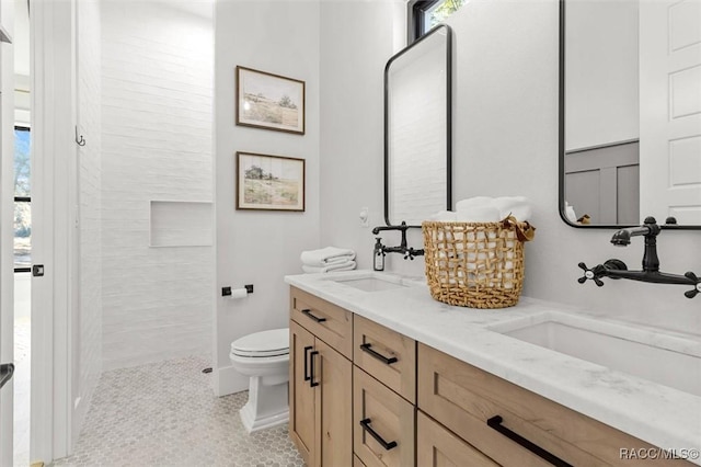 bathroom featuring plenty of natural light, tile patterned floors, vanity, and toilet