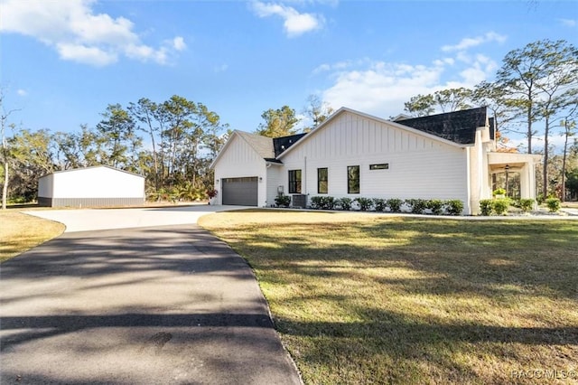 modern farmhouse with a front lawn, a garage, and central AC