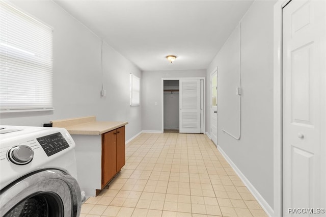 clothes washing area with light tile patterned floors and washer / dryer