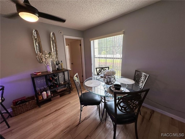 dining room featuring ceiling fan, a textured ceiling, and light wood-type flooring