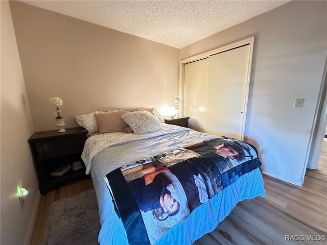 bedroom with hardwood / wood-style floors, a closet, and a textured ceiling