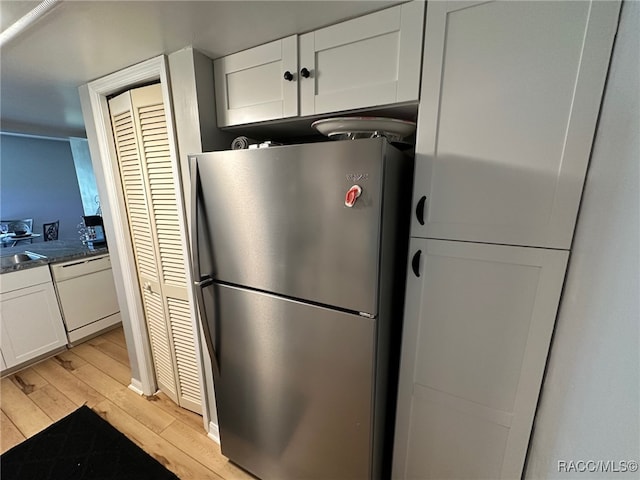 kitchen featuring sink, light hardwood / wood-style flooring, stainless steel refrigerator, dishwasher, and white cabinets