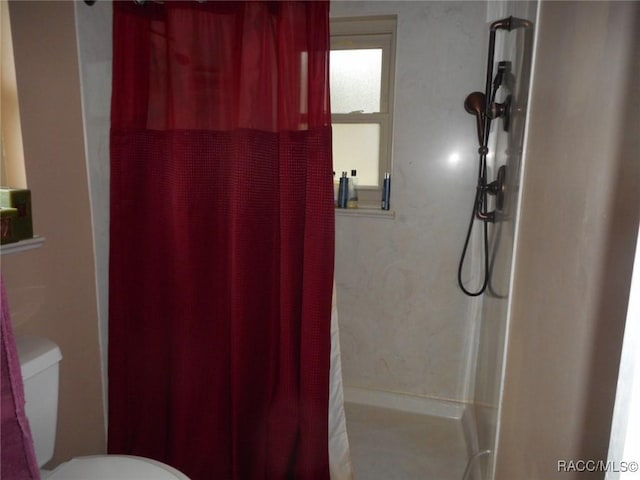 bathroom with a shower with curtain and toilet