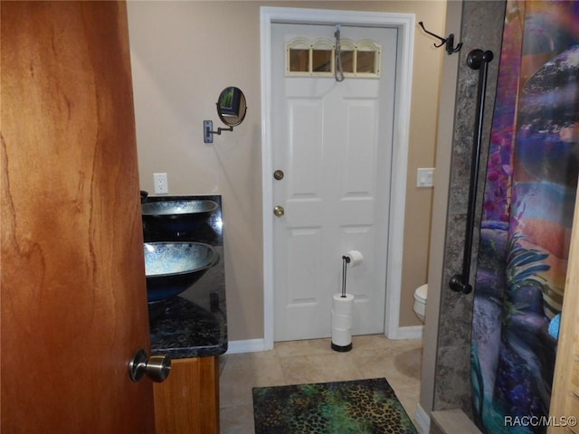 bathroom with toilet, a shower with curtain, vanity, and tile patterned floors