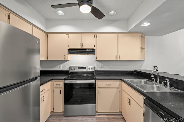 kitchen with sink, hardwood / wood-style flooring, ceiling fan, a textured ceiling, and stainless steel appliances