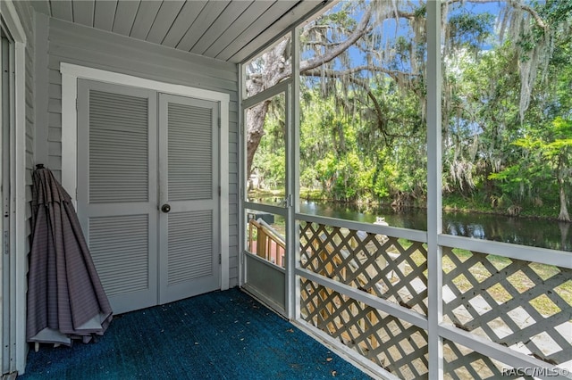 unfurnished sunroom with a water view