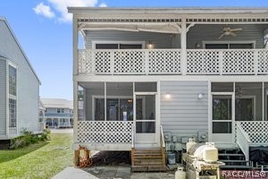 rear view of house with ceiling fan and a sunroom