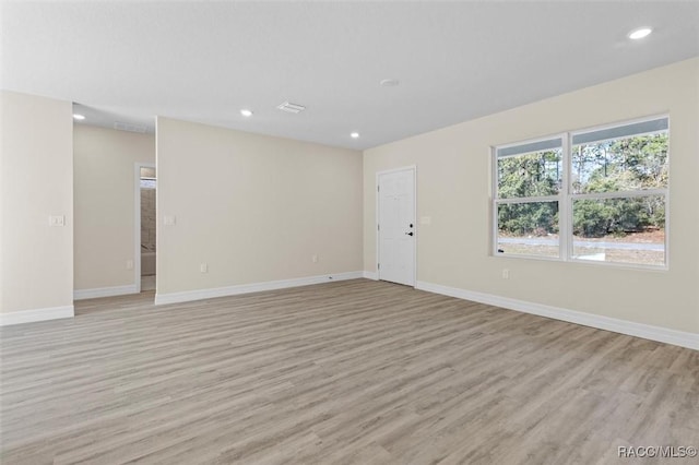 spare room with light wood-style floors, baseboards, and recessed lighting