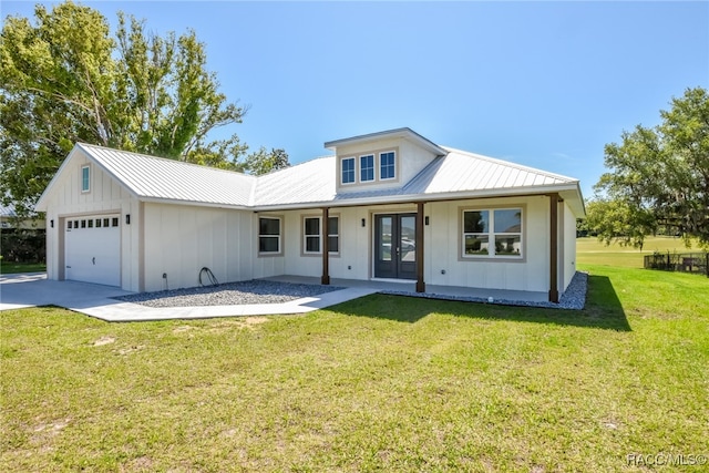 view of front of house featuring french doors, a garage, and a front lawn