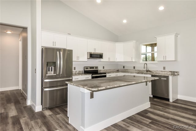 kitchen with white cabinets, dark hardwood / wood-style floors, a center island, and appliances with stainless steel finishes