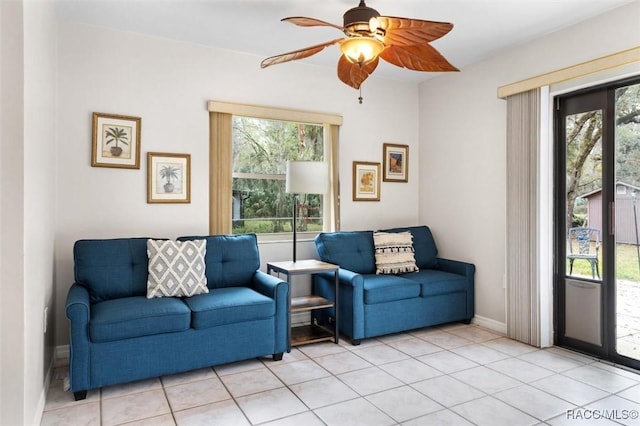 living room featuring ceiling fan, plenty of natural light, light tile patterned flooring, and baseboards