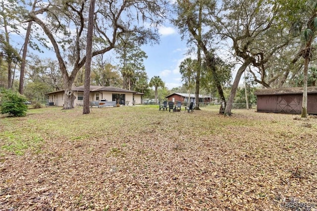 view of yard featuring fence and an outdoor structure