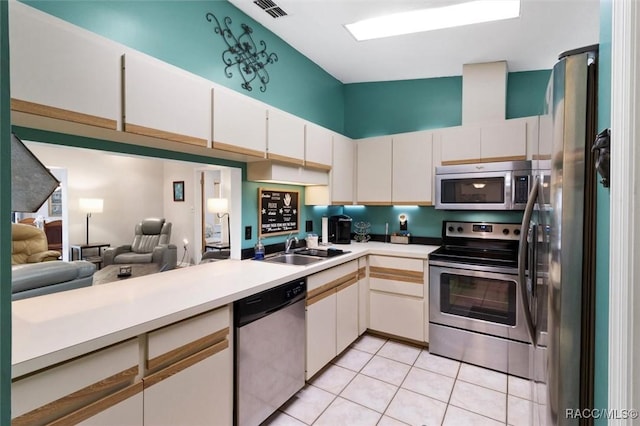 kitchen with stainless steel appliances, light countertops, a sink, and light tile patterned floors