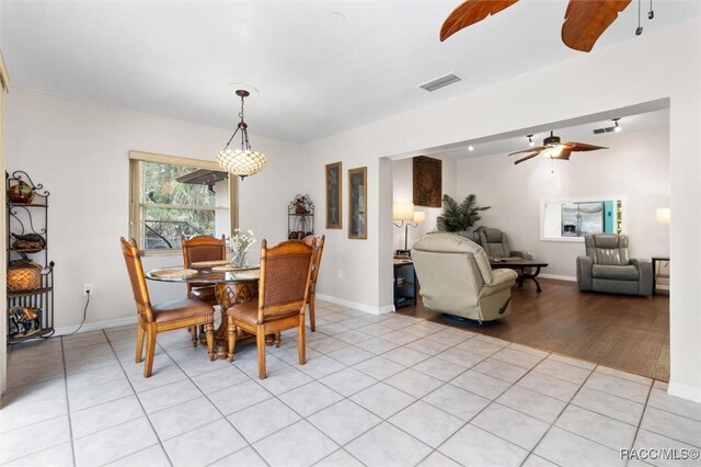 dining space featuring light tile patterned floors, ceiling fan, visible vents, and baseboards