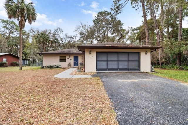 view of front of home with driveway, an attached garage, and stucco siding